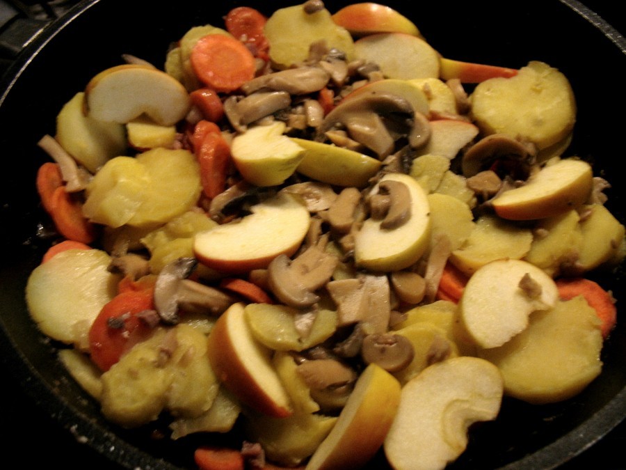 Zwiebelwürfel, Katenschinken, Karotten-, Kartoffelscheiben, Apfelspalten und Champignons werden vermengt und leicht mit Pfeffer und Salz gewürzt.  