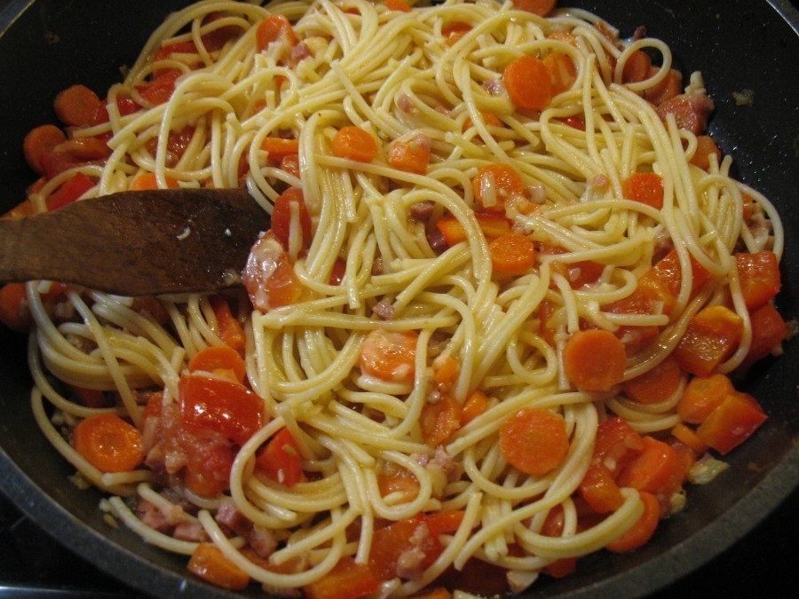 Die Spaghetti werden zur Gemüse-Schinken-Mischung gegeben und mit 50 g Reibekäse untergehoben.