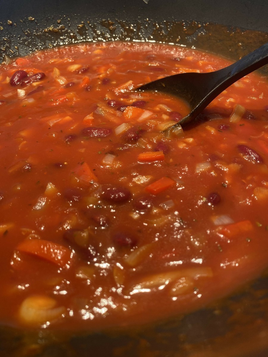 Zwiebel, Knoblauch und Paprika klein schneiden und in etwas Öl anbraten. Suppenwürfel hinzugeben und mit den passierten Tomaten ablöschen. Kidneybohnen ebenfalls hinzugeben.