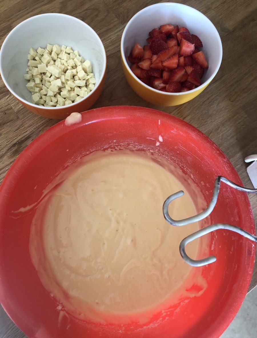Die Erdbeeren und weiße Schokolade schneidet man in kleine Stücke. Der Teig besteht aus flüssigen und festen Zutaten. Am Ende wird alles kurz und kräftig verrührt.