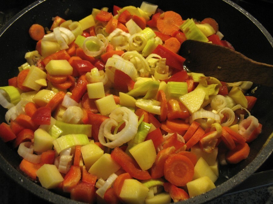 Das Gemüse und die Gemüsebrühe werden dazugegeben, dann wird alles abgedeckt etwa 15 Minuten bei mäßiger Hitze gegart.