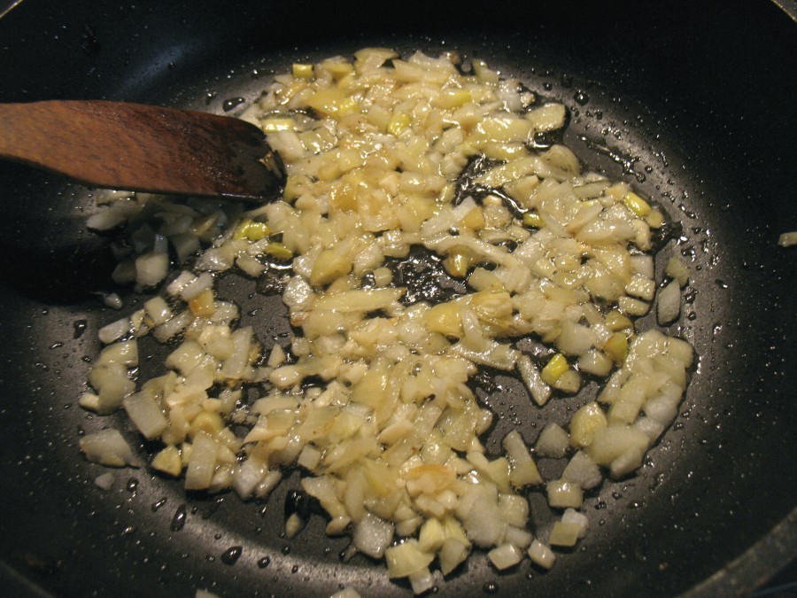 In einer großen Pfanne wird das Öl erhitzt und darin Zwiebelwürfel und Knoblauch kurz angebraten.