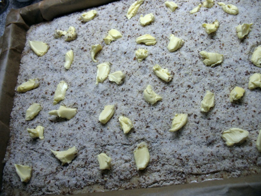 Den flüssigen Teig verteilt man auf dem Backblech, darüber kommt die Mandel-Zucker-Mischung und zum Schluss die Butter in kleinen Flöckchen.