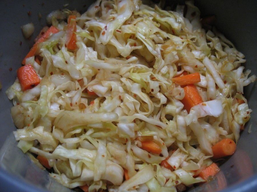 Die Würzpaste gibt man zum Kohl-Karotten-Gemisch und mischt alles mit den Händen gut durch.