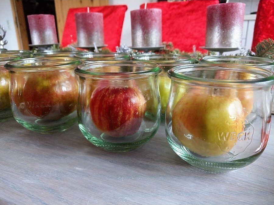 Die gefüllten Äpfel in die Gläser legen und für den Backofen vorbereiten. Sie werden bei 200 Grad gebacken.