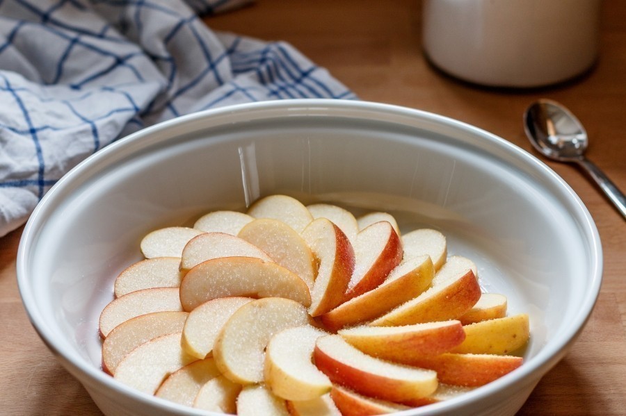 Die Äpfel in eine flache runde Auflaufform auslegen und mit etwas Vanillinzucker und Calvados bestreuen (muss aber nicht).