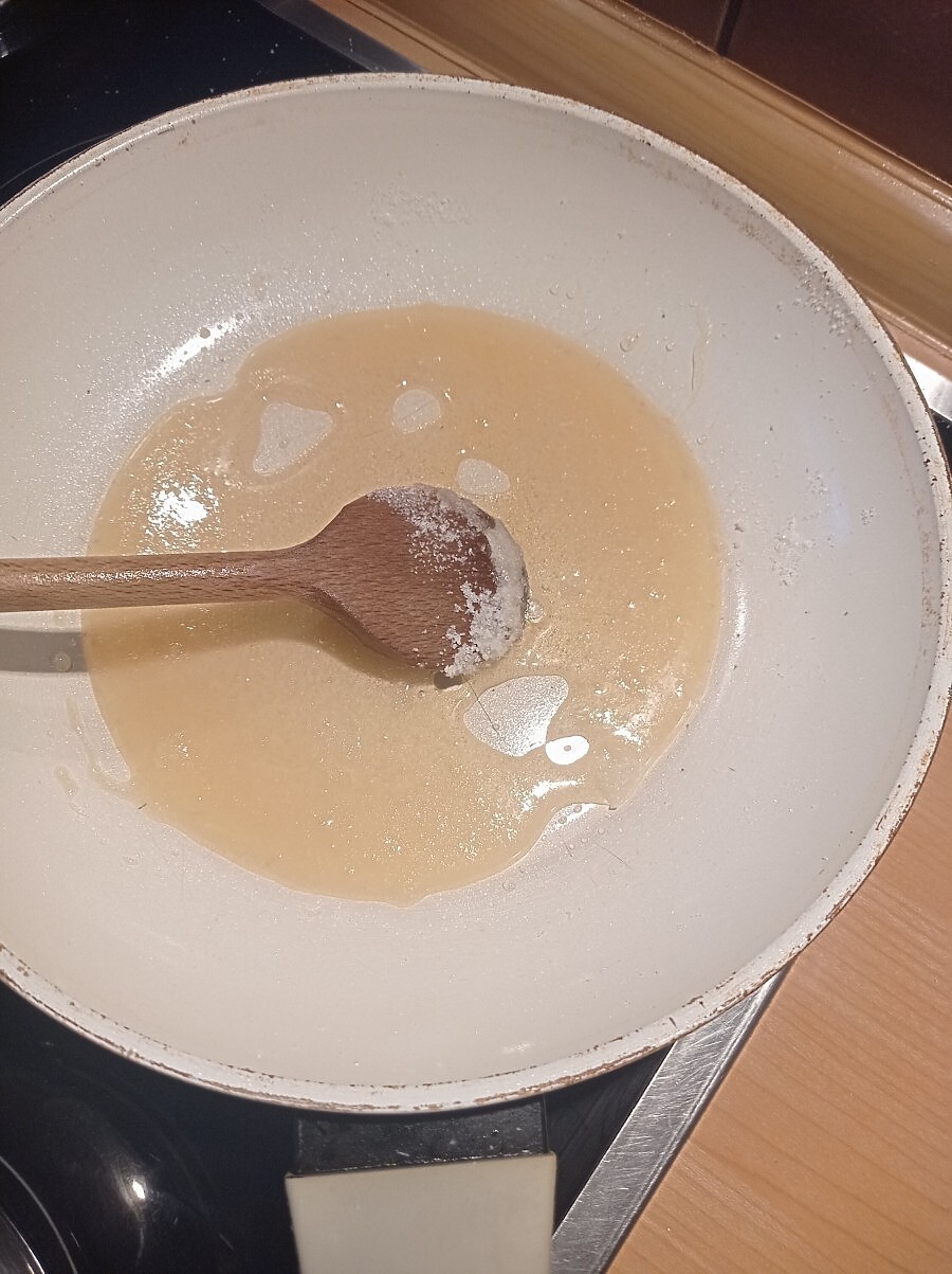In einer kleinen Pfanne wird der Zucker für das Karamell für die glasierten Möhren geschmolzen.