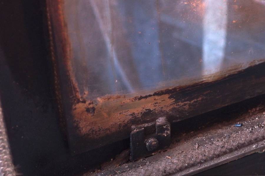 Reinigen der Glasscheibe vom Holzofen mit einem Schmutzradierer.