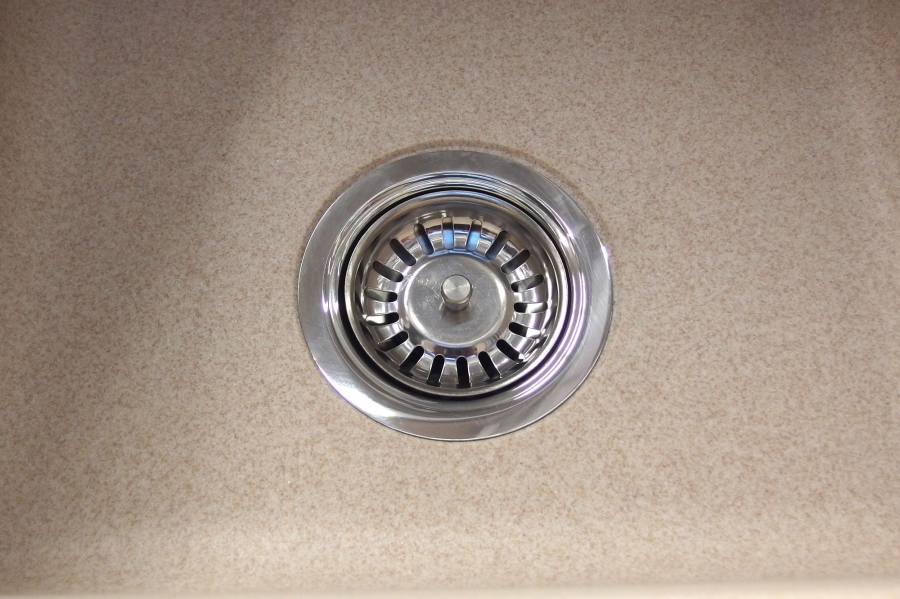 Beläge des Abflusssiebes der Küchenspüle mit einem Schmutzradierer reinigen.