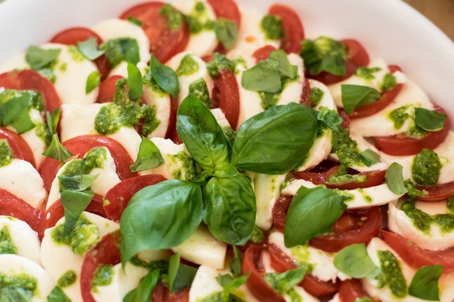 Die Tomaten und den selbstgemachten Mozzarella in Scheiben schneiden und im Kreis schichten.
