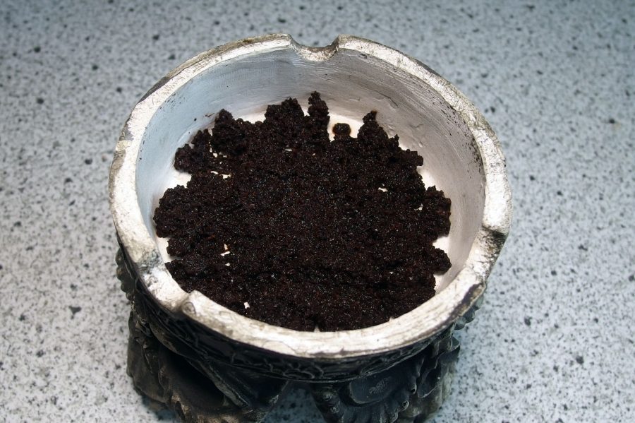 In den Boden des Aschenbechers eine dünne Schicht gemahlenen Kaffee geben.