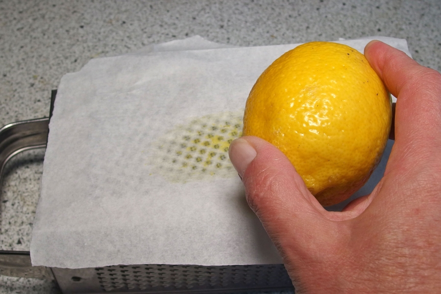 Damit man nicht mühselig die Reibe putzen muss, hier ein simpler Trick:  Ihr nehmt ein Stück Pergament/Butterbrotpapier zwischen Reibe und Zitrone.