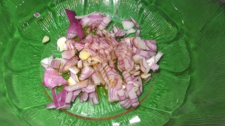 Eine in Öl zerdrückte und verrührte Zwiebel sorgt für eine würzigere Salatsoße. Erst danach werden die restlichen Zutaten der Soße untergerührt.