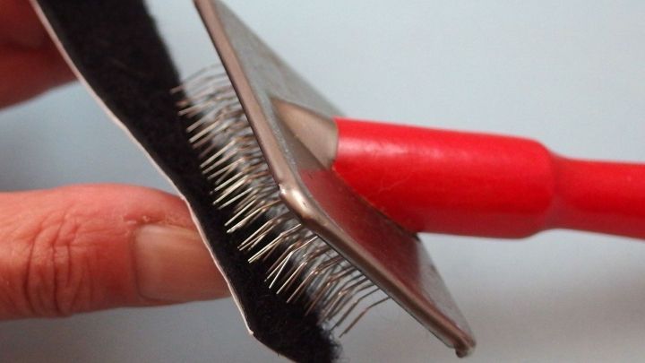 Verfusselte Klettverschlüsse reinigen mit einer Drahtbürste für Tierfellpflege.
