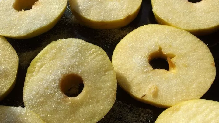 Als Vorbereitung für die Apfelpfannkuchen werden die Äpfel in Scheiben geschnitten und mit Zucker bestreut.