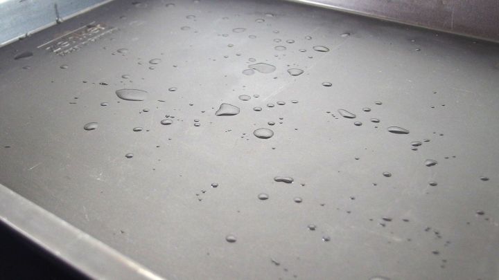 Mit ein paar Tropfen Wasser auf dem Backblech rutscht das Backpapier nicht mehr.