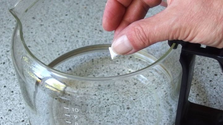 Eingebrannten Kaffee in Glaskanne mi Spülmaschinen-Reinigertabs entfernen.