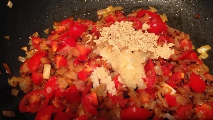 Die Tomatenwürfel, Korianderpulver, Kurkuma, Chilipulver, etwas Salz dazugeben.