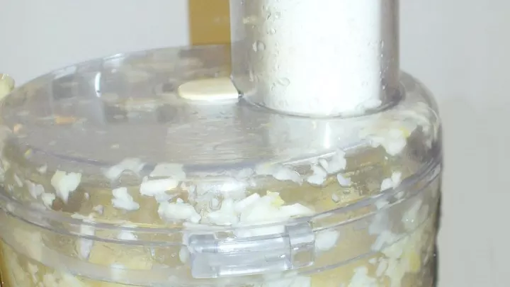 Zitronenstücke und Knoblauchzehen in einem Mixer zerkleinern.