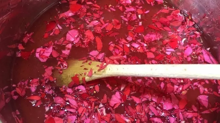 Zwischendurch müssen noch die roten Rosenblätter fein gehackt und kurz vor dem Ende der Kochzeit dazugegeben werden..