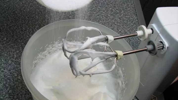 Die Eiweiß mit einer Prise Salz cremig steif schlagen. Während des Schlagens den Zucker nach und nach einrieseln lassen.
