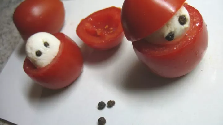 Die Tomaten werden gewaschen, dann schneidet man an der spitzen Seite der Tomaten etwa ein Drittel von der Höhe ab, für die Mütze des Weihnachtsmännchens.