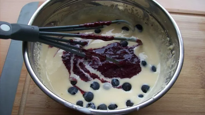 Nachdem die Masse ein wenig abgekühlt ist, wird der Joghurt untergerührt und drei EL der pürierten Beeren werden ebenfalls in die Creme gegeben.