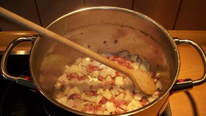 In einem Topf wird jetzt die Margarine/das Öl erhitzt und die gewürfelten Zwiebeln werden kurz angebraten. Hinzu kommt auch das auf mundgerechte Stückchen geschnittene Rindfleisch.