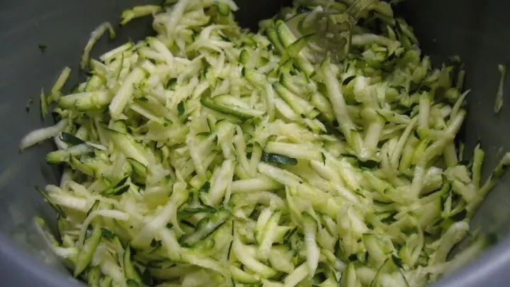 Die Zucchini wird gewaschen, fein geraspelt und etwas gesalzen, dann lässt man die Masse 5 Minuten ziehen.