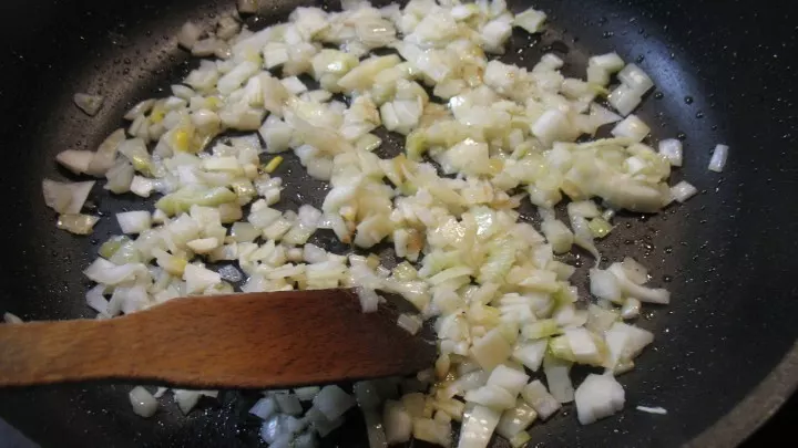 Die fein gewürfelten Zwiebeln und die fein gehackten Knoblauchzehen werden im heißen Öl glasig angedünstet.