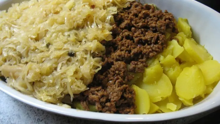 In eine gefettete Auflaufform werden nacheinander die Kartoffelscheiben, das Hackfleisch und das Sauerkraut geschichtet.