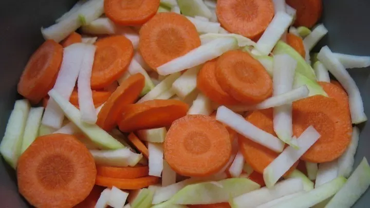 Die Karotten waschen, schälen und in dünne Scheiben schneiden oder hobeln, Kohlrabi putzen, schälen und in dünne Stifte schneiden.