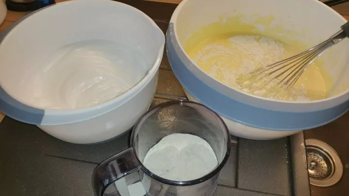 Eigelbe mit Vanillezucker und 100 g Zucker mit dem Mixer cremig rühren, die Quarkmasse mit dem Schneebesen unterheben.  