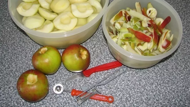 Die Apfelspalten in der einer Schüssel sammeln, Schale und Kerngehäuse in einer zweiten.