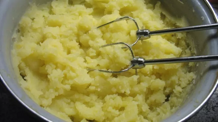 Die Kartoffelwürfel werden mit etwas Restwasser mit den Rührbesen des Handmixers verrührt.