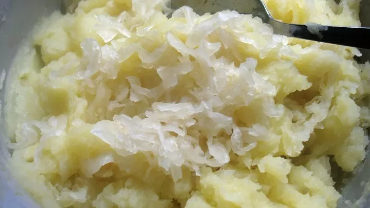Das Sauerkraut wird unter das heiße Kartoffelpüree gemischt.