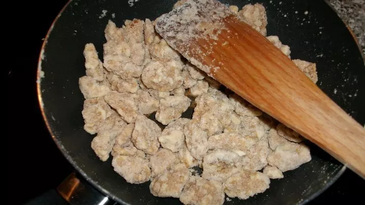 Die Walnüsse so lange kochen, bis der Zucker trocken wird. Dabei ständig mit einem Kochlöffel rühren. 