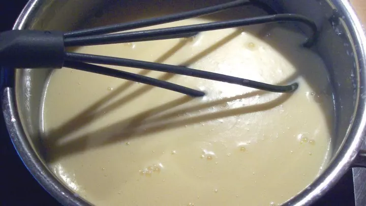 Für den Pudding: Ei, Eigelbe, Zucker, Vanillezucker bzw. Vanille-Extrakt und Stärke in einem Topf unter Zuhilfenahme eines Schneebesens miteinander vermengen.