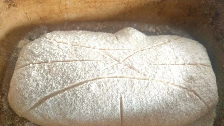 Das Brot in den Römertopf legen, mit Mehl bestäuben oder Körnern bestreuen. Nun kann in das Brot ein Muster geritzt werden, damit es nicht unkontrolliert reißt. Wie ihr schneidet, ist dabei egal.