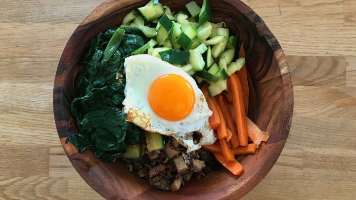 Bibimbap ist ein koreanisches Resteessen und enthält Reis, Gemüse, Tofu und/oder Rindfleisch, eine koreanische Chilipaste (Gochujang) und ein Ei.