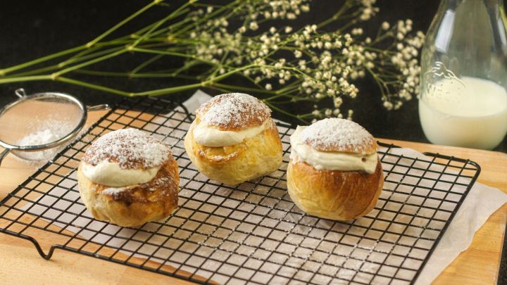 Die süßen Semlor sind perfekt für jede Kaffeepause. Das schwedische Gebäck wird mit einer Marzipanmasse und Sahne gefüllt und erinnert an Windbeutel.