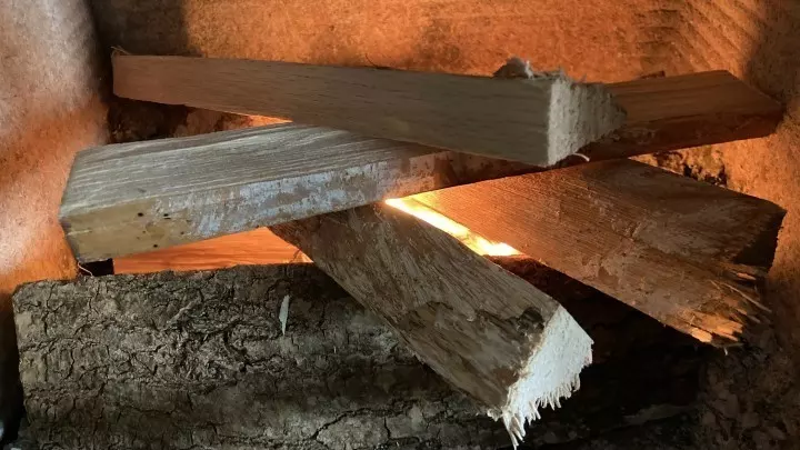 Nun kann der Anzünder angezündet werden. Die Anzündhölzer brennen schnell und entflammen die beiden größeren Holzstück, die unten liegen.