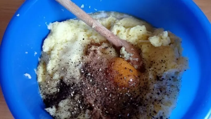Die geriebenen Kartoffeln werden mit Zwiebeln, Ei, Salz, Muskat und reichlich Pfeffer gut gewürzt.