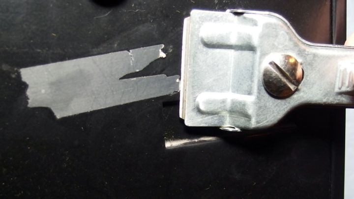 Mit einem Glaskeramikfeldschaber Klebereste vom Briefkasten entfernen.