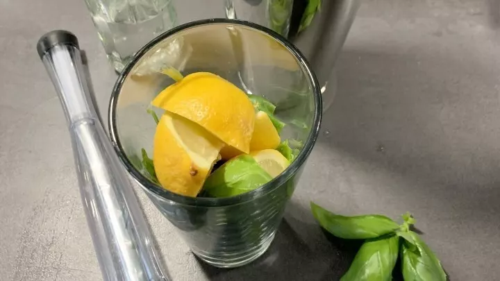 Gib je 4 Zitronen-Achtel, 4 Stängel Basilikum und 2 cl Zuckersirup in einen Cocktail-Shaker oder in ein großes Glas mit Schraubdeckel.