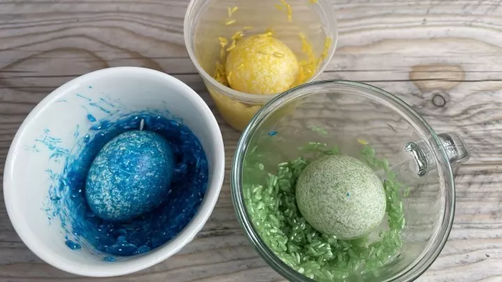 Einblick in den Färbeprozess: Eier werden vorsichtig in bunt gefärbtem Reis gewendet - probiere es selbst aus!