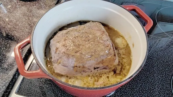 Die Unterseite mit Schweineschmalz kräftig anbraten. Die grob geschnittenen Zwiebeln auf den Topfboden legen. Fleisch drauf legen.