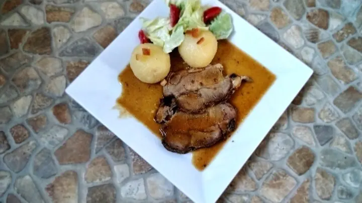 Schweinebraten mit Senfkruste und Biersoße fertig bereit für den Tisch. Ein kleines Salatbouquet dazu und natürlich Kartoffelknödel. 