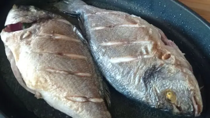 Die Doraden-Haut wird eingeschnitten, gewürzt und in einer Pfanne auf beiden Seiten je 5 Minuten angebraten.