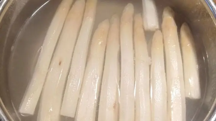 Der Spargel wird geschält und in kochendem, mit Salz und einer Prise Zucker gewürzten Wasser leicht bissfest gegart. 